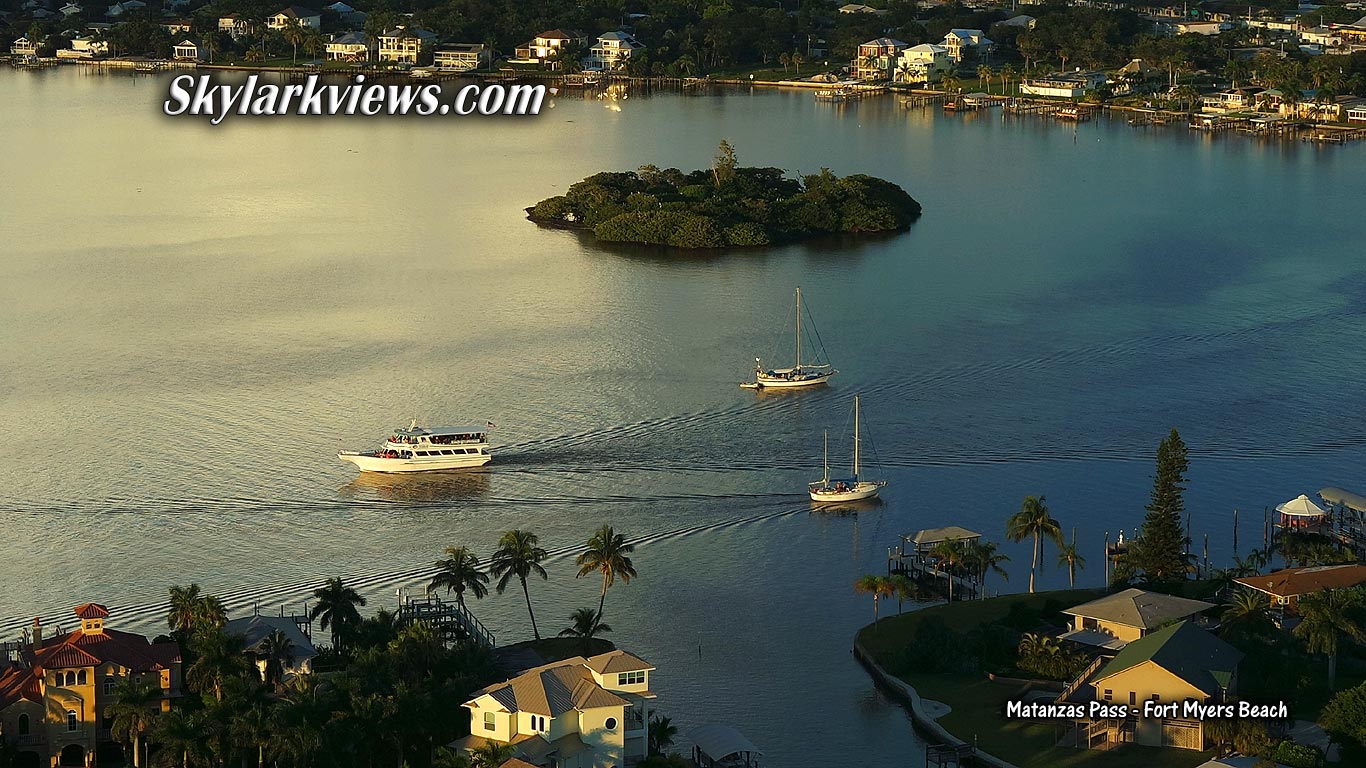 aerial view to boats, houses and palm trees at sunset