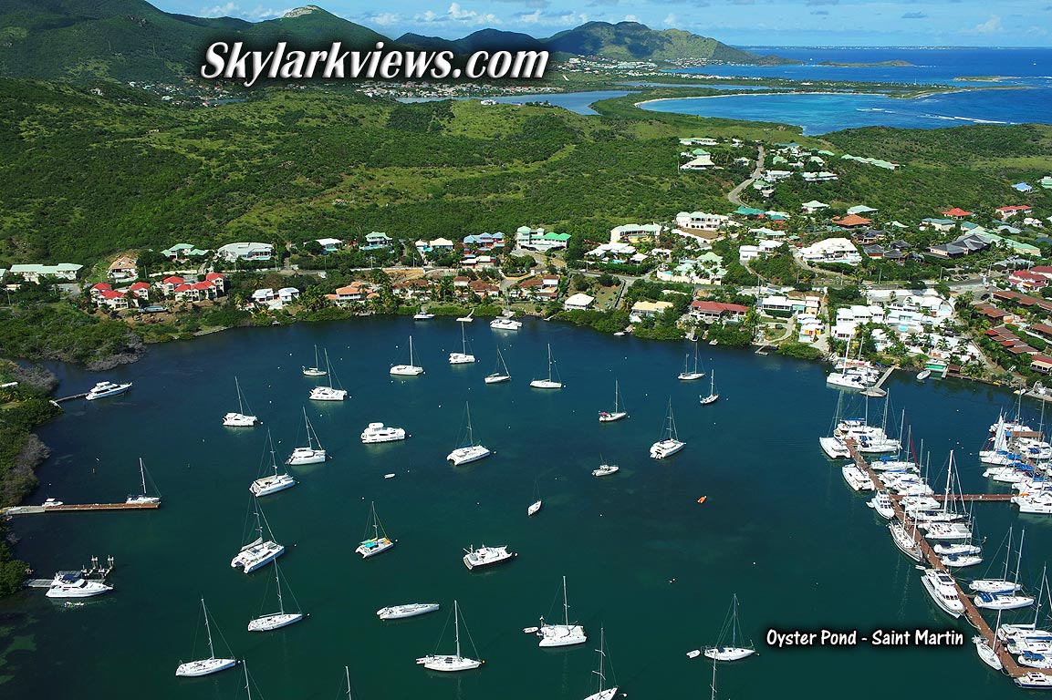 bay full of sailboats, houses, far view