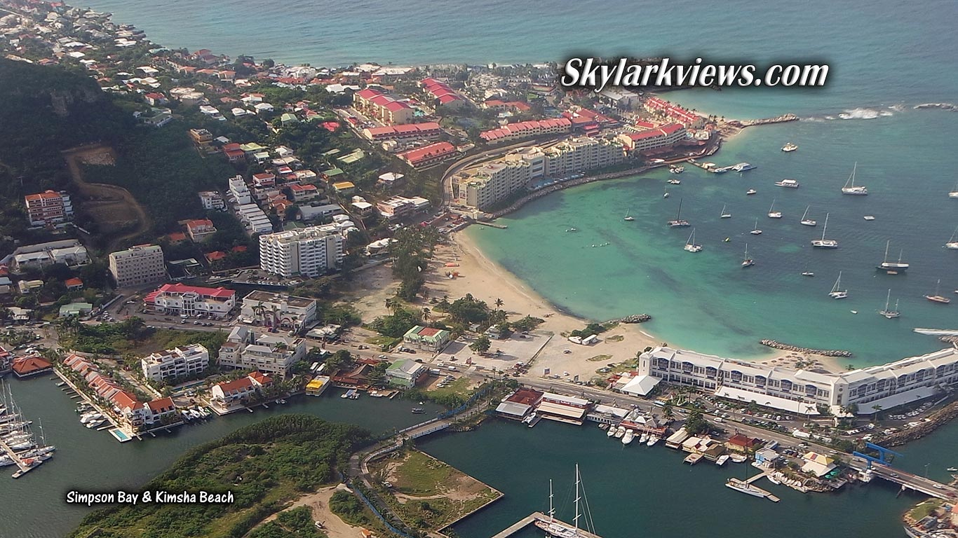 view from airplane: bay, hotels, houses and boats